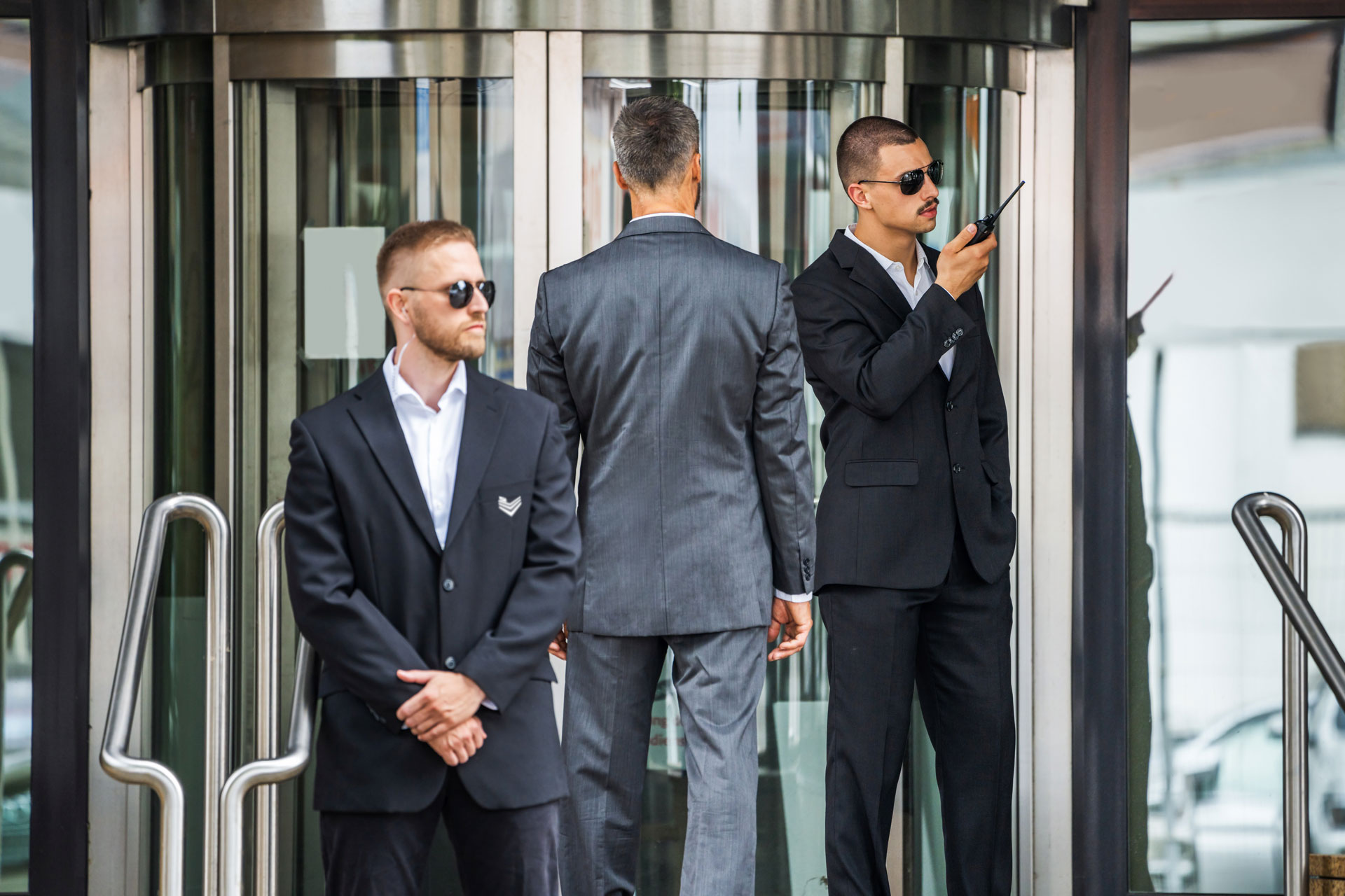 Two security guards tracking suspicious visitors in a hospital.